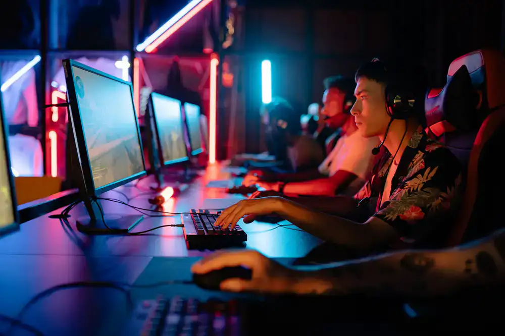 Esports players in dark arena with glowing monitors
